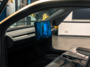 A picture of a man's face on a monitor in a car