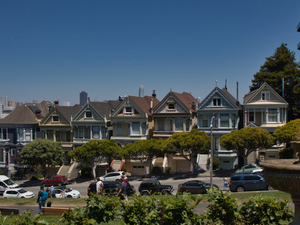 a row of houses with cars parked in front of them
