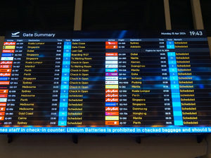 A large screen displaying a flight schedule at an airport
