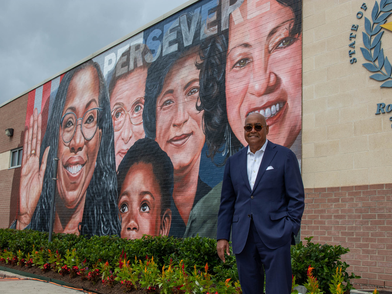 Ellis stands in front of a mural honoring Supreme Court Justice Ketanji Brown Jackson