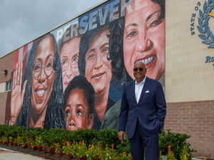 Ellis stands in front of a mural honoring Supreme Court Justice Ketanji Brown Jackson