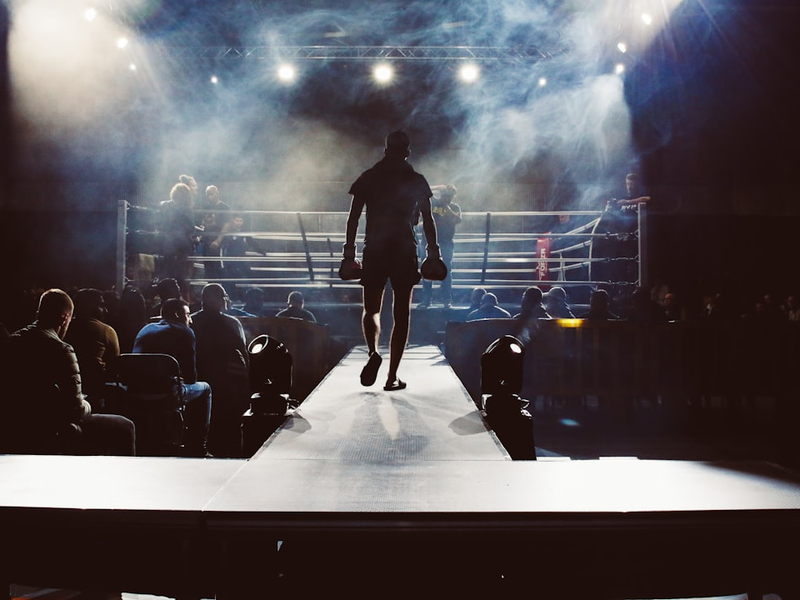 man standing and walking going on boxing ring surrounded with people