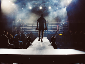 man standing and walking going on boxing ring surrounded with people