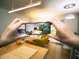 Virtual tour. Hands holding smartphone taking pictures for selling apartment.