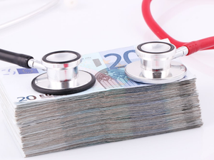 a pile of money with a stethoscope on top of it