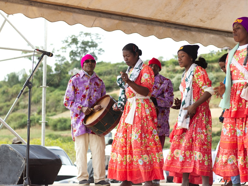 People in colorful traditional clothing performing on stage.
