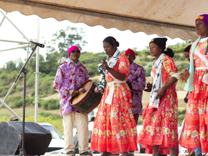 People in colorful traditional clothing performing on stage.