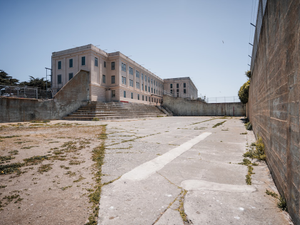 A large, imposing prison building under a clear sky.