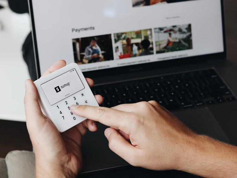 A person using a SumUp card reader, entering the transaction amount manually on the device. This image emphasizes the user-friendly interface for quick payment processing.