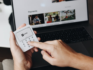 A person using a SumUp card reader, entering the transaction amount manually on the device. This image emphasizes the user-friendly interface for quick payment processing.