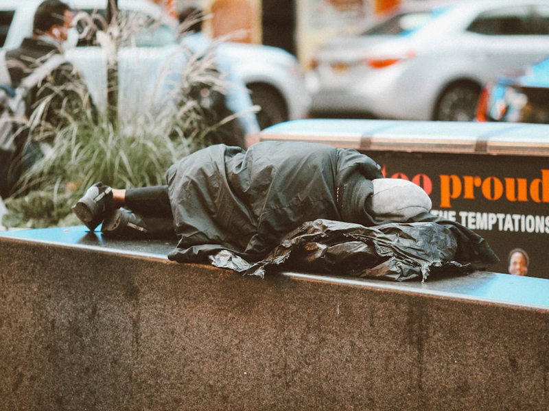 a homeless man sleeping on a city street