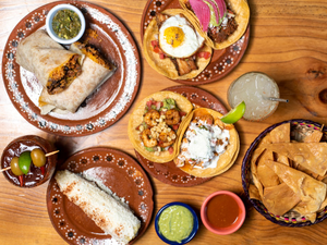 A wooden table topped with plates of food