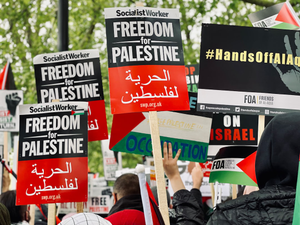 people holding red and white banner during daytime