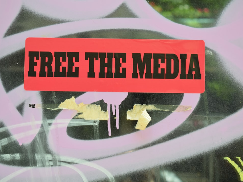 a red sign that reads free the media