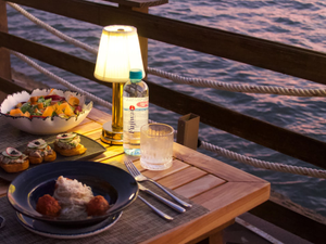 Table set for dinner by the water at dusk