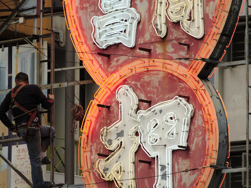 Man repairs neon sign from pawn shop in Hong Kong