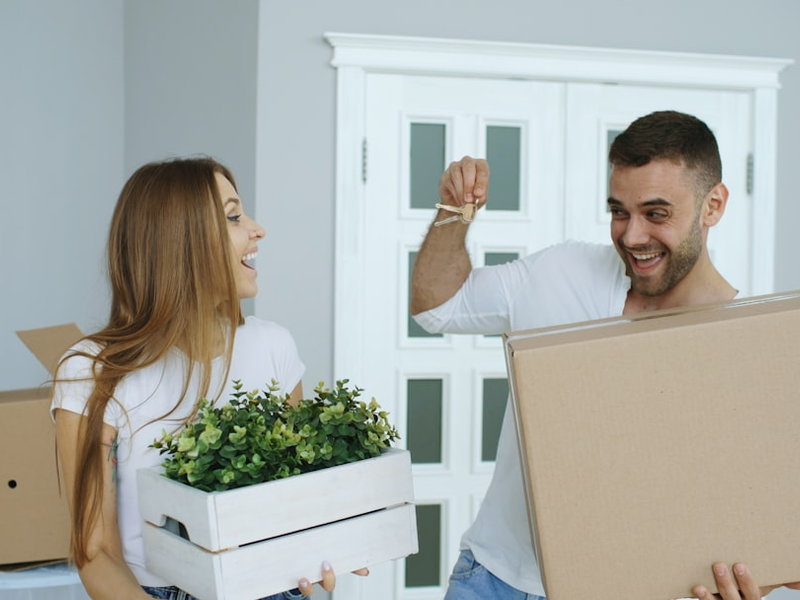 Happy couple watching their new home excited. Young man give keys from house to his girlfriend and kissing her