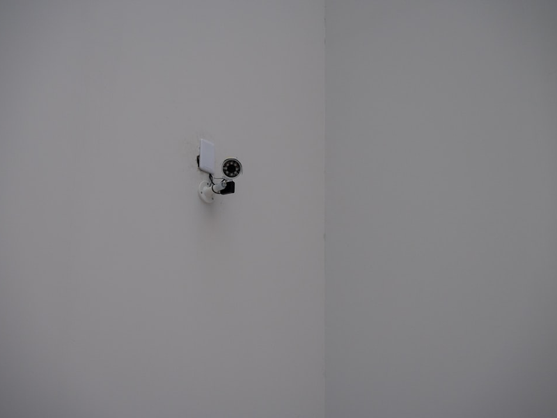 A security camera mounted in a white corner.