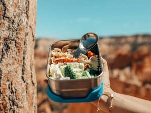 Eco friendly super hero with plastic free eco lunch box in nature. Zero waste ocean friendly living with stainless steel tiffin bento box containers by ECOlunchbox.
