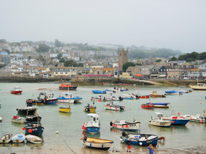 Misty harbour scene, full of fishing boats and two lifeboats at St Ives, Cornwall, England UK