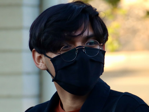 man in black framed eyeglasses and black collared shirt