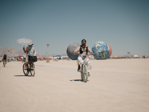 Burning Man Festival - in Nevada Black Rock City Couple on the background with Art Car in a Desert. Photographer Anton Mislawsky