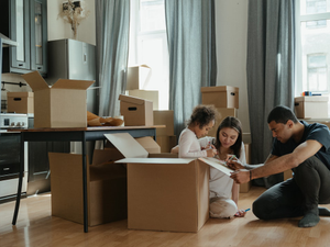 a man and a little girl are sitting on the floor in front of boxes