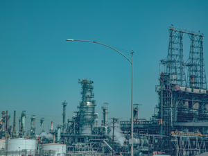 Industrial oil refinery complex under a clear blue sky
