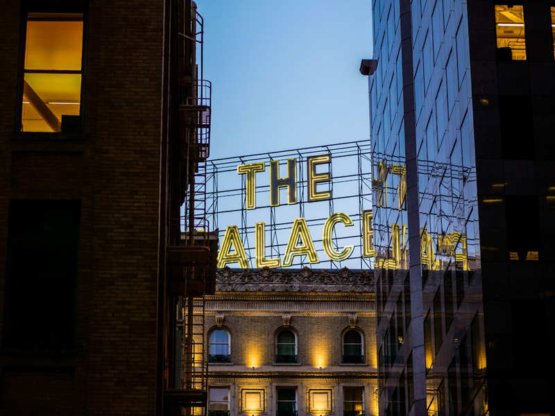 The Palace Hotel neon sign through the buildings of San Francisco.