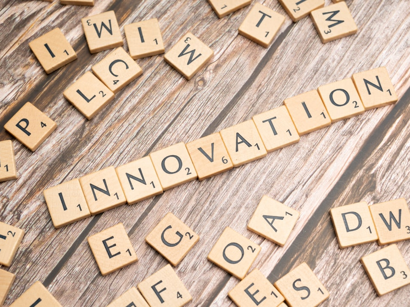 scrabble tiles spelling the word innovation on a wooden surface