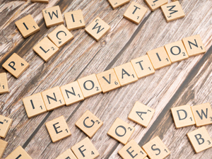 scrabble tiles spelling the word innovation on a wooden surface