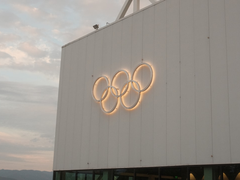 White building with illuminated olympic rings symbol