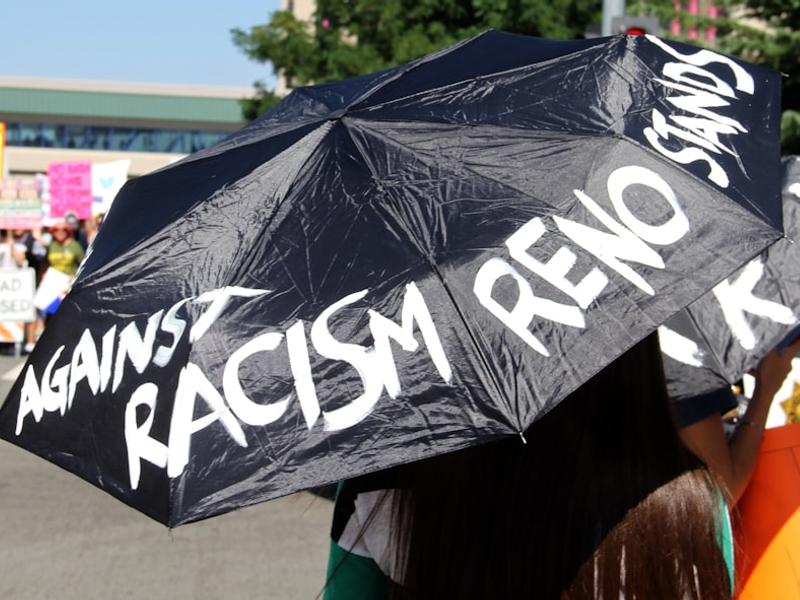woman in black and white t-shirt holding black umbrella