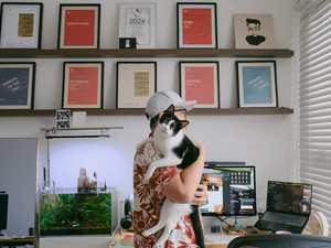 Person holding a cat in an office setting