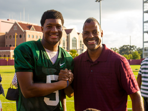 Volunteer guardian ad litem and community supporter Omega Wynn with Florida State Seminoles quarterback Jameis Winston (5) at the Albert J. Dunlap Athletic Training Facility football practice fields in Tallahassee, Florida on October 8, 2013.