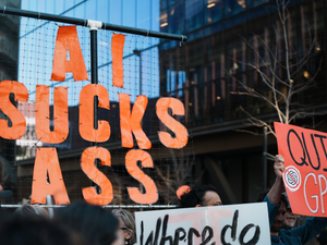 Protestors hold signs against ai and gpt.