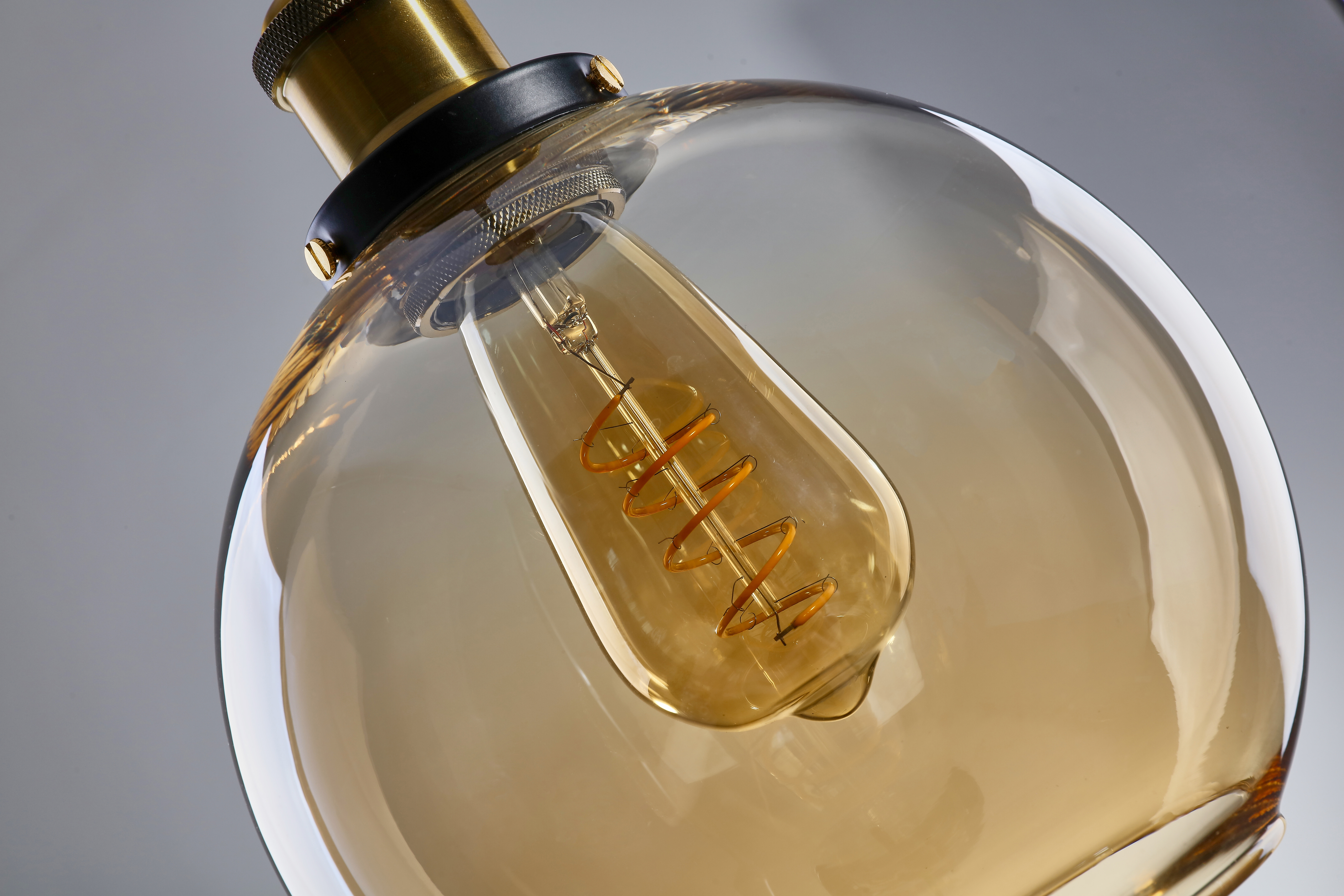 glowing, spiral-filament bulb within a round, amber-tinted glass cover
