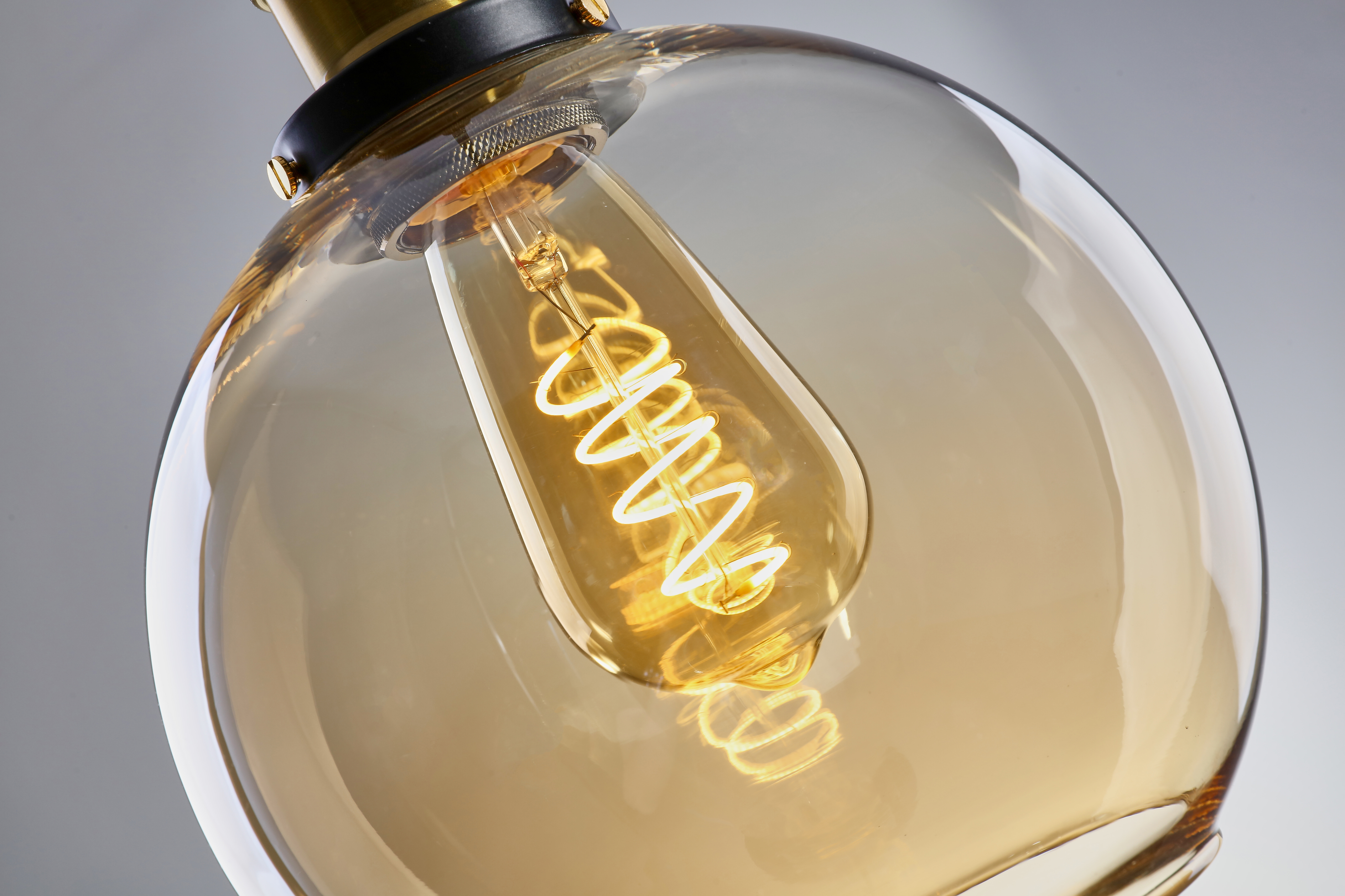 glowing, spiral-filament bulb within a round, amber-tinted glass cover