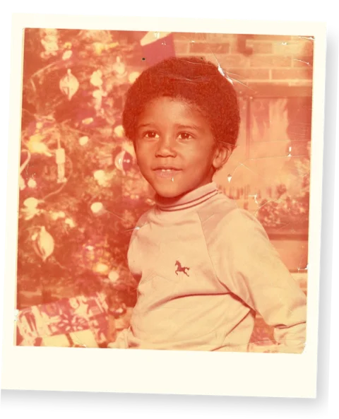 Childhood photo of Alex Jones as a young boy in front of a Christmas tree