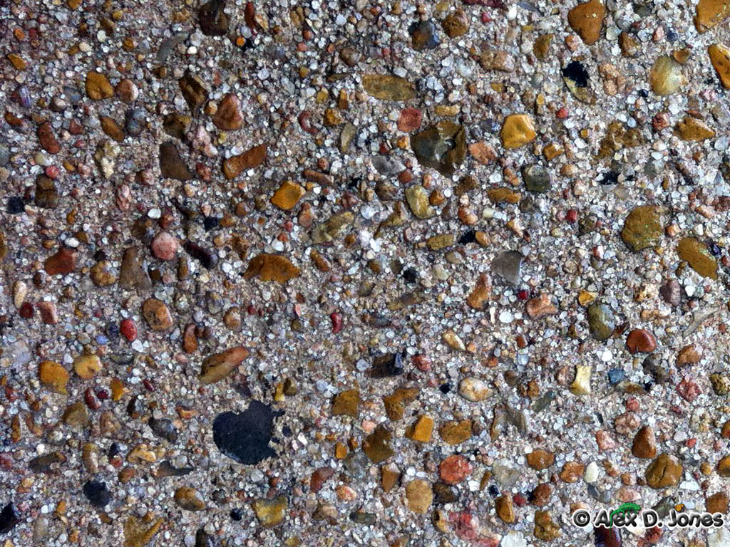 This image shows concrete with many different colored rocks and pebbles mixed inside.