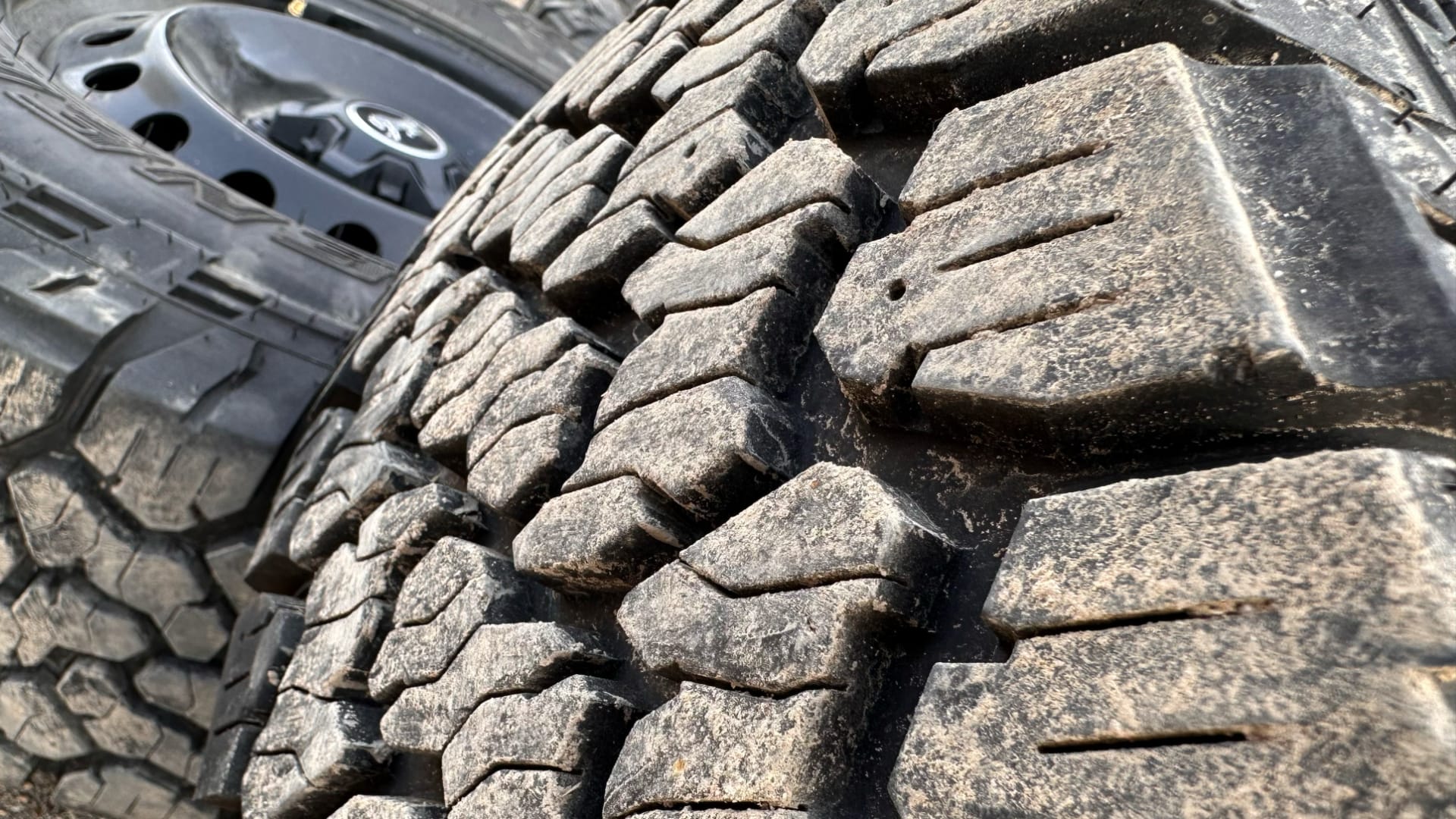 This photo shows a close-up view of a car tire's tread pattern—the deep grooves and bumpy texture on the rubber surface.