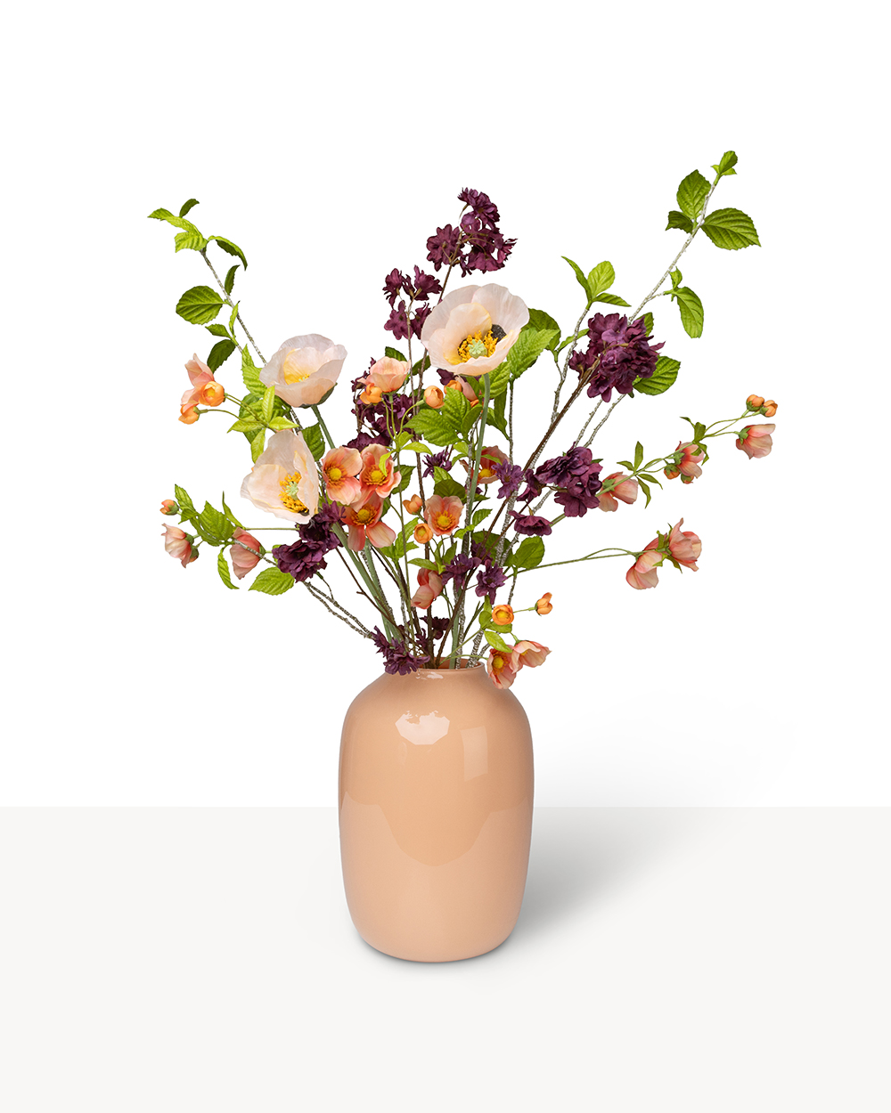 Boeket met perzikkleurige en dieppaarse zijden bloemen in een gladde perzikkleurige keramische vaas.