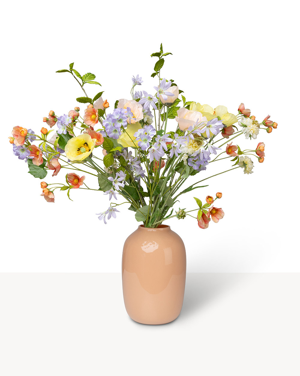 Een boeket van kleurrijke zijden bloemen in pasteltinten, waaronder geel, lila en perzik, in een perzikkleurige vaas.