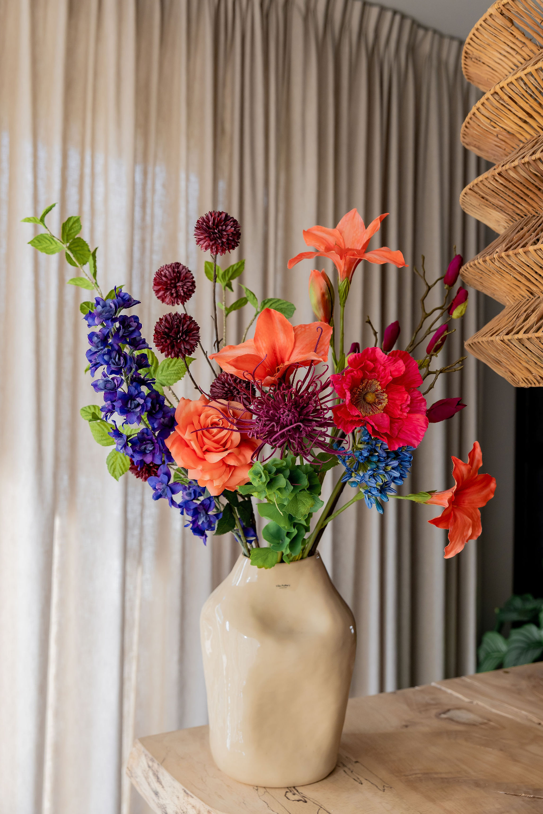 Boeket zijden bloemen met oranje amaryllissen, een zalmroze roos, paars ridderspoor, donkerrode alliums, een paarse dahlia en felroze bloemen in een c
