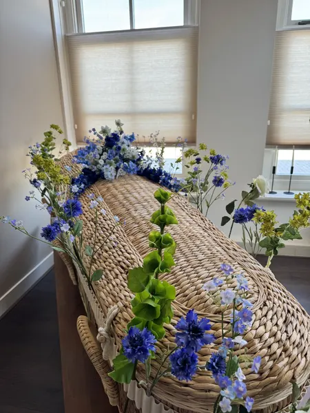 Zijden veldbloemen in blauw en groen op een rieten kist