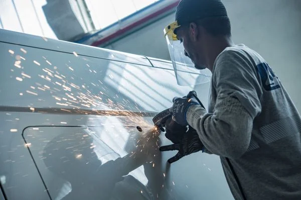 Foto di un operatore Silor che ritaglia per creare sede per installazione dei finestrini