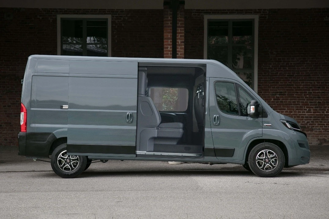 Foto di un furgone grigio con la porta laterale aperta da cui si intravede un allestimento Crew Cab