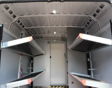 Foto dell'interno di un veicolo commerciale allestito con ripiani ribaltabili