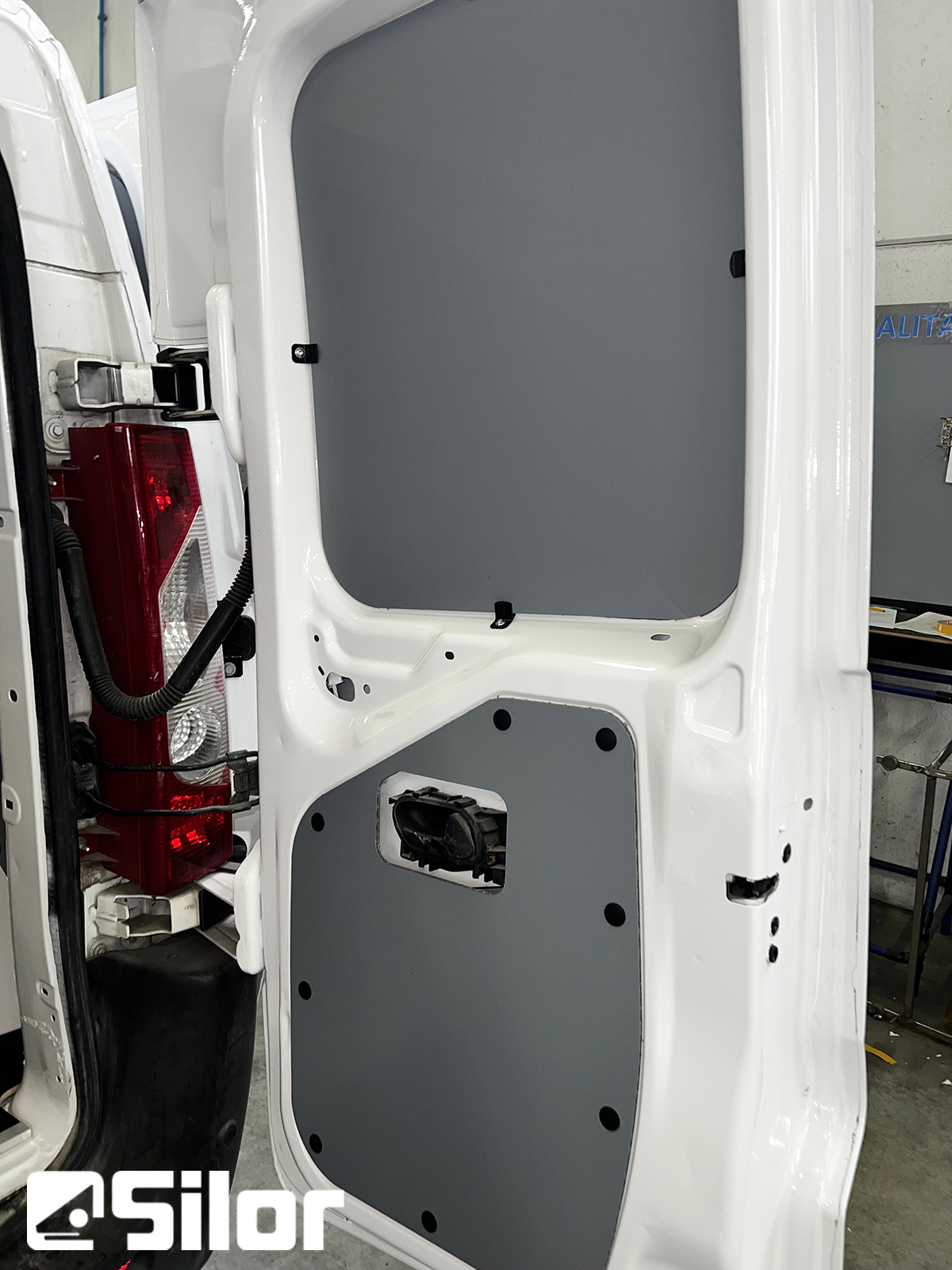 Porta furgone imbiancata con pannello grigio.