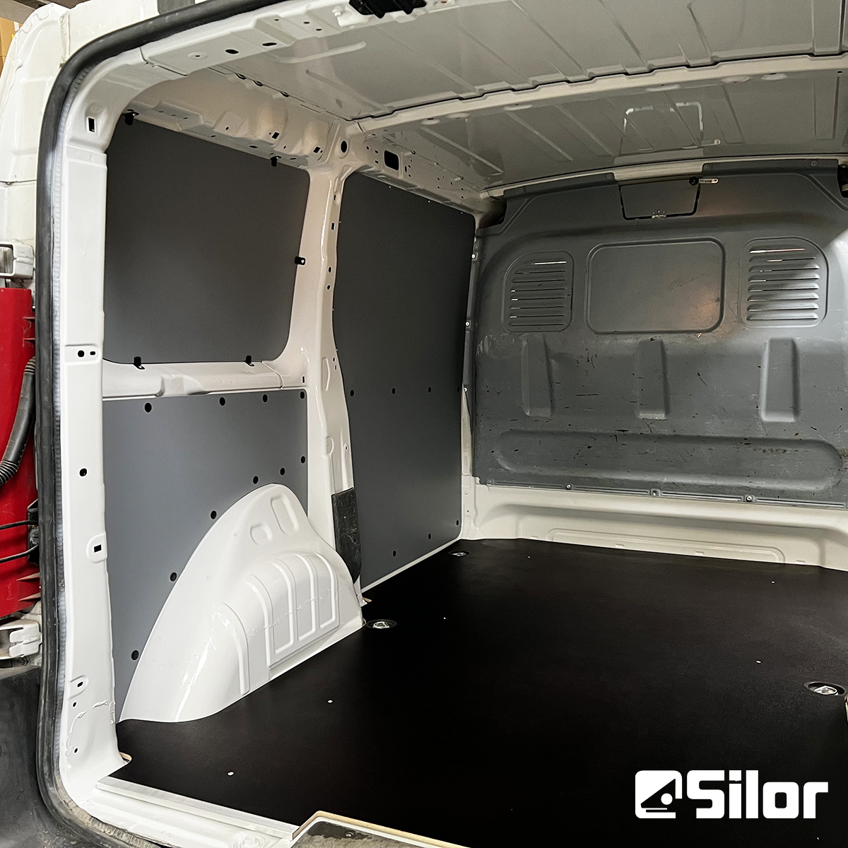 Interno di un furgone merci con rivestimenti protettivi e pavimento in gomma.